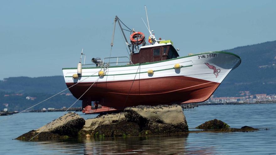 Un pesquero de Rianxo aparece varado sobre unas rocas en plena bajamar en As Sinas