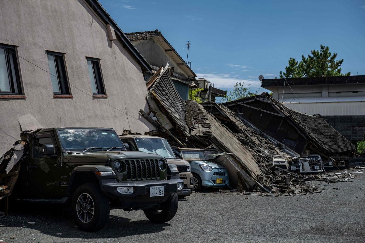 Se ven automóviles aplastados bajo una casa derrumbada en Yatsushiro, prefectura de Kumamoto, el 29 de julio de 2026, después de que un terremoto sacudió el suroeste de Japón el día anterior. (Foto de Yuichi YAMAZAKI / AFP)