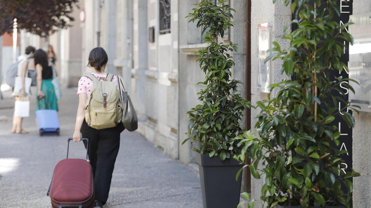 Una turista amb una maleta al centre de Girona.