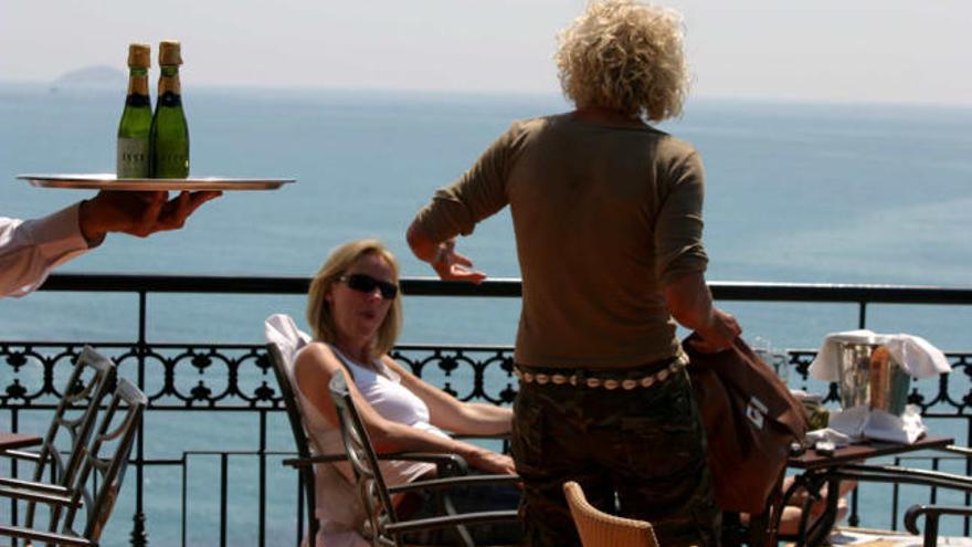 Una pareja de turistas disfruta en la terraza de un hotel de la Costa Blanca mientras esperan ser atendidas por un camarero.