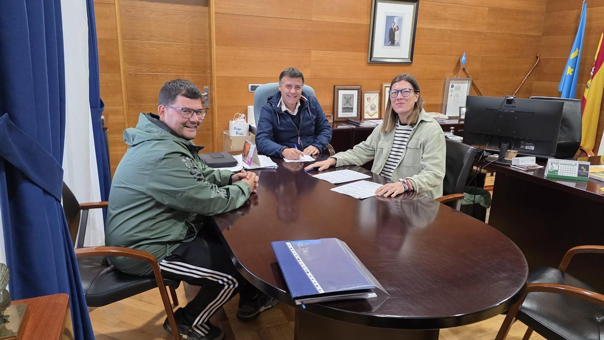 El concejal de Deportes y el alcalde cangués, José Luis Fontaniella, durante la firma con la presidenta del club de baloncesto local.