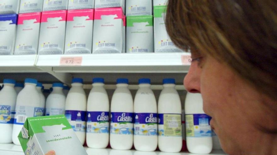 Una consumidora triant la llet en un supermercat