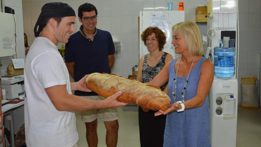 Per l&#039;esquerra el forner de El Cruixent Jordi Sánchez mostra una barra de pa a Jordi Pellicer, Neus Piniella i Maria Àngels  Sallés