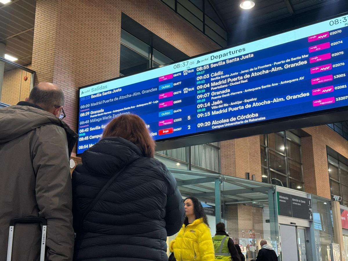 Viajeros observan los tiempos de salida y llegada de los trenes en Córdoba Julio Anguita, este martes por la mañana.