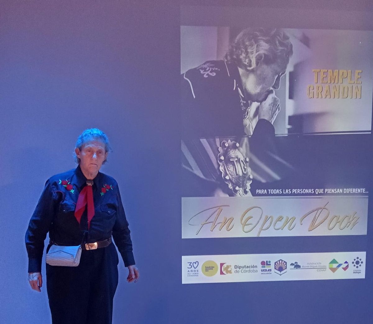 Temple Grandin, junto al cartel promocional de su documental 'An open door'.