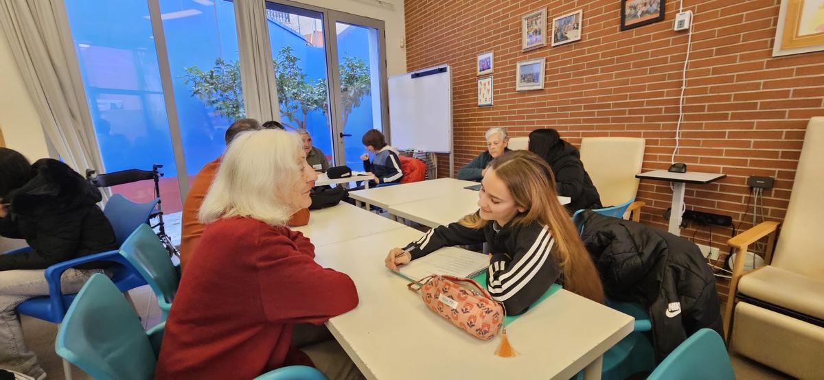 Els alumnes de l'IES Benicalap al Centre de Dia de l'AFAV al barri, entrevistant als usuaris.