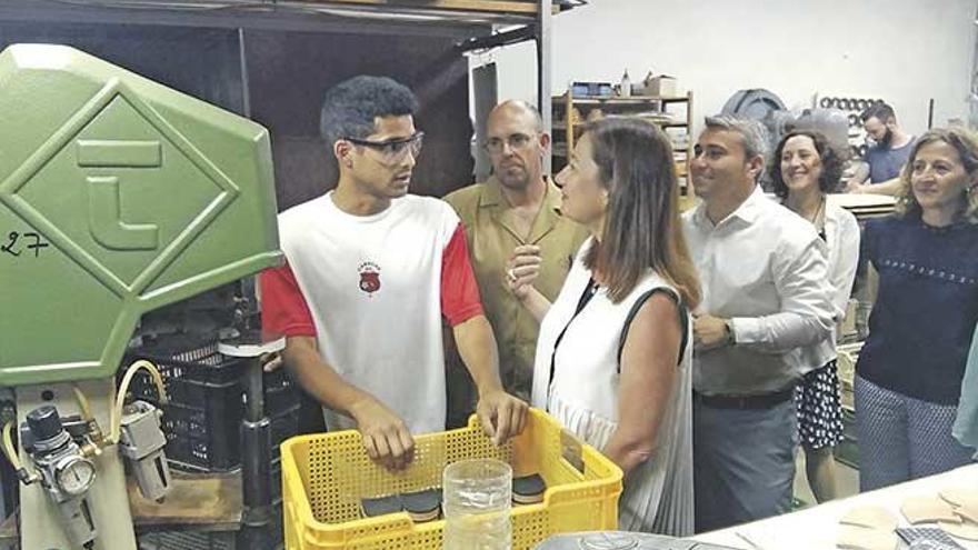 Francina Armengol conversa con uno de los alumnos que hacen prácticas en Carmina Shoemaker.