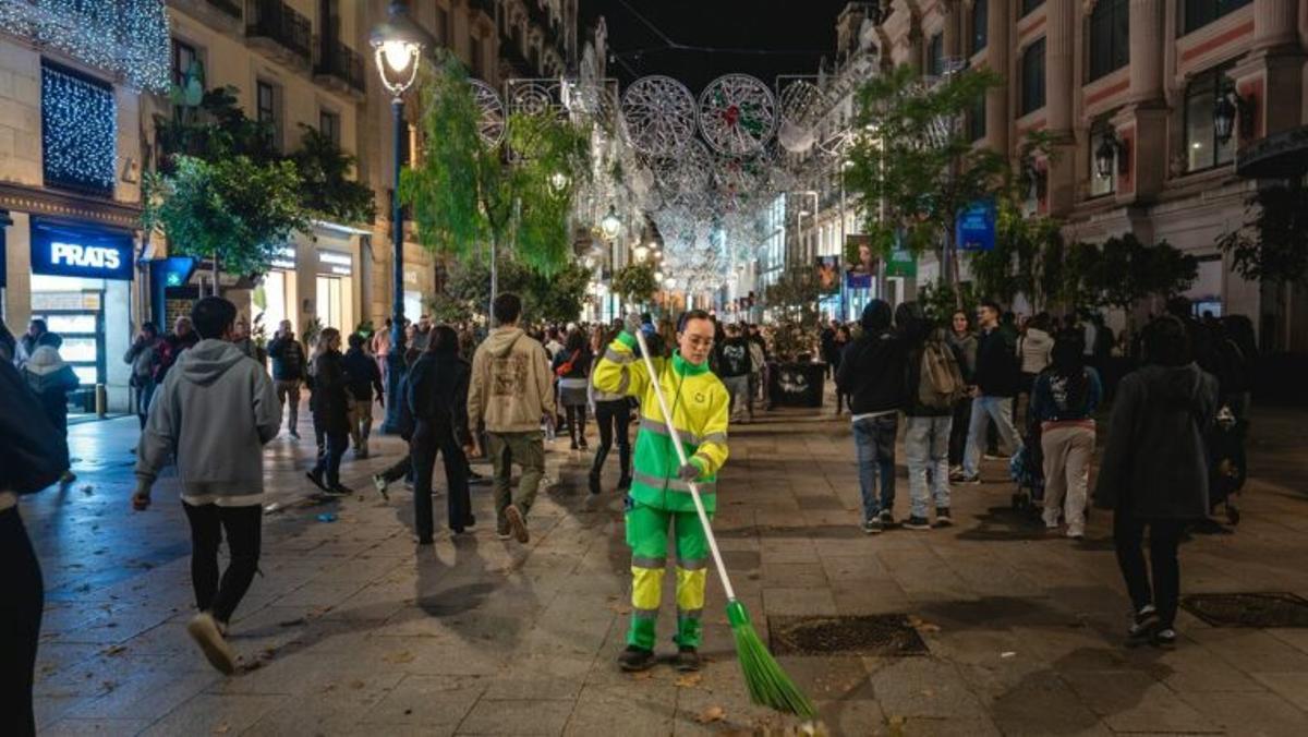 Una operaria de Cuidem Barcelona barre el Portal de l’Àngel