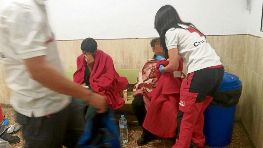 Una imagen de los dos menores que llegaron a Torrevieja siendo atendidos por personal de la organización humanitaria Cruz Roja.