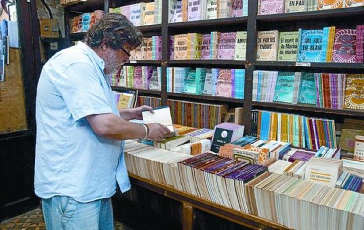 Interior de la llibreria 8 Lluís Millà consulta un text en un racó ple de llibres. Interior de la llibreria 8 Lluís Millà consulta un text en un racó ple de llibres.