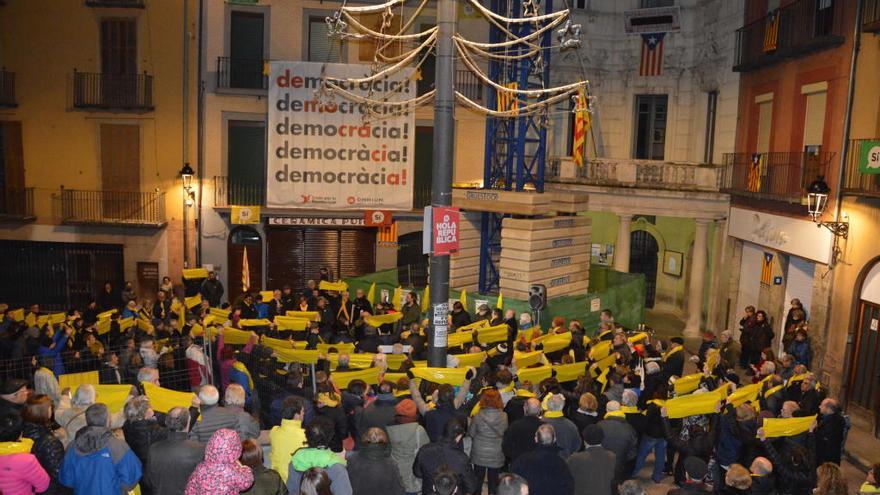 Assistents a la concentració alçant  plàstics grocs en el minut de silenci a la plaça de Sant Pere de Berga