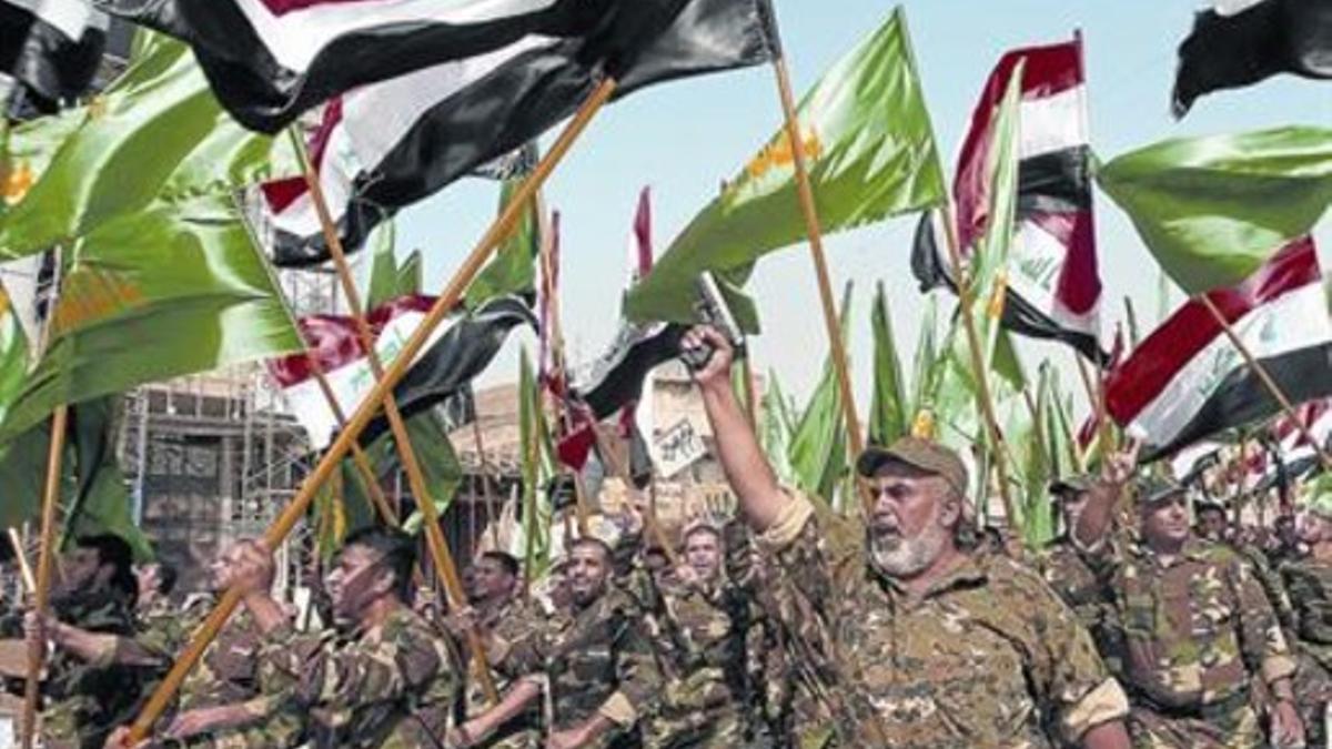 Combatientes chiís desfilan con armasy banderas por Bagdad, ayer.