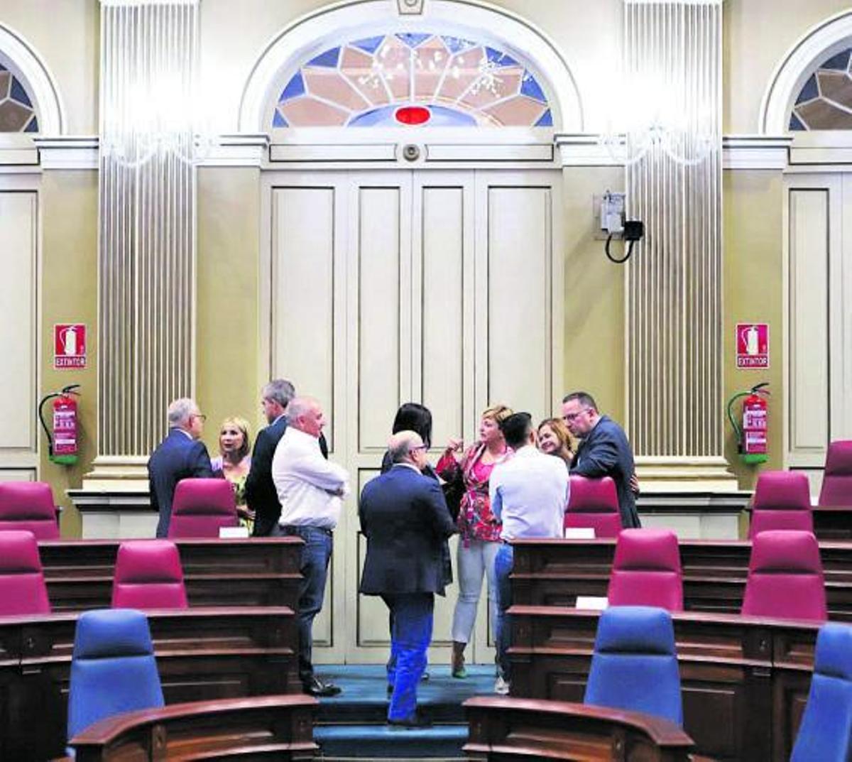 Portavoces y diputados de los grupos parlamentarios charlan en el hemiciclo de la Cámara autonómica. | | E.D.