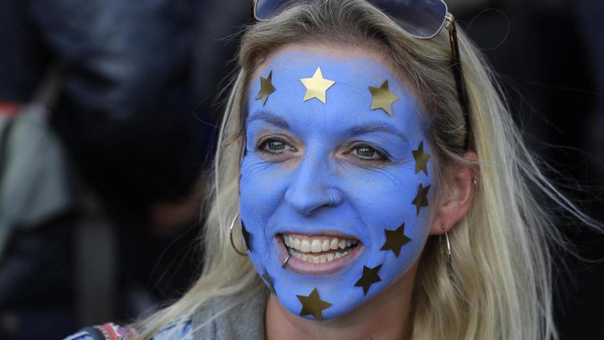Una mujer con la bandera de la UE pintada en la cara.