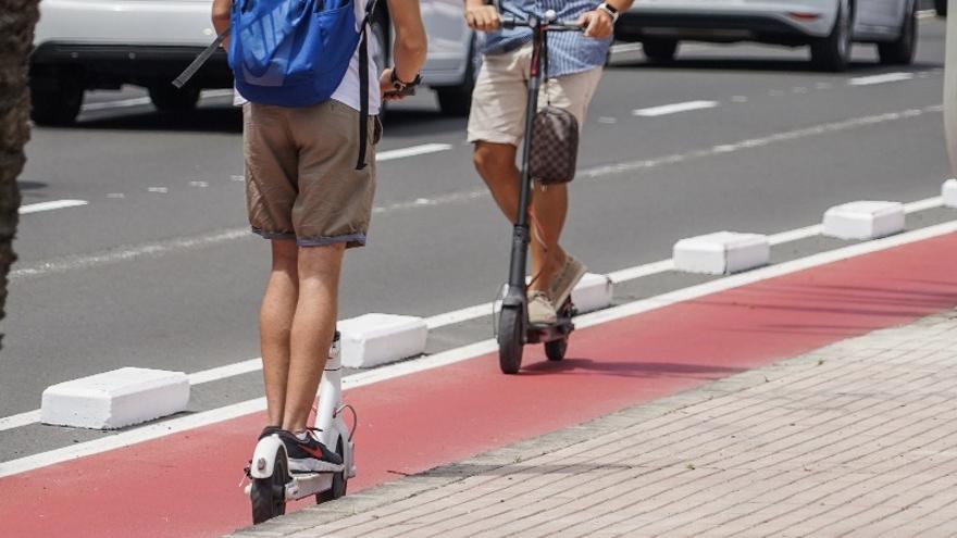 Imagen de dos personas circulando en patineta eléctrica por el carril bici capitalino.