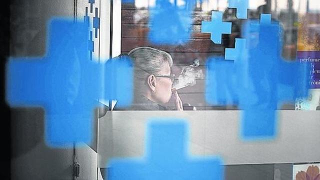 Una mujer fumando frente al Hospital del Mar.