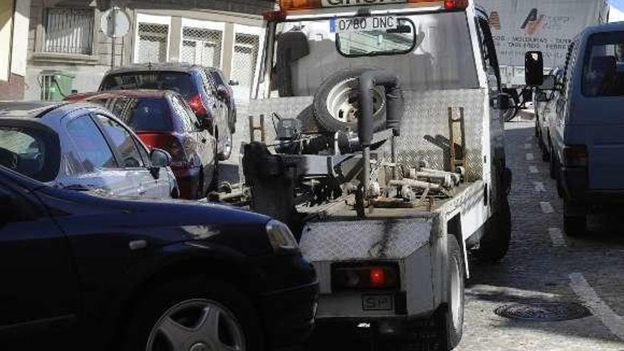 Una grúa retira un coche aparcado en la Ciudad Vieja.