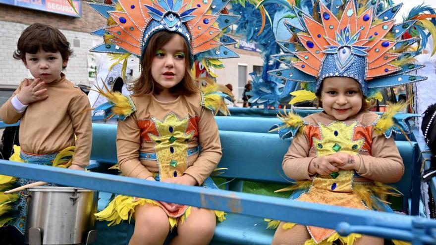 Niños disfrutan de la fiesta con una comparsa.