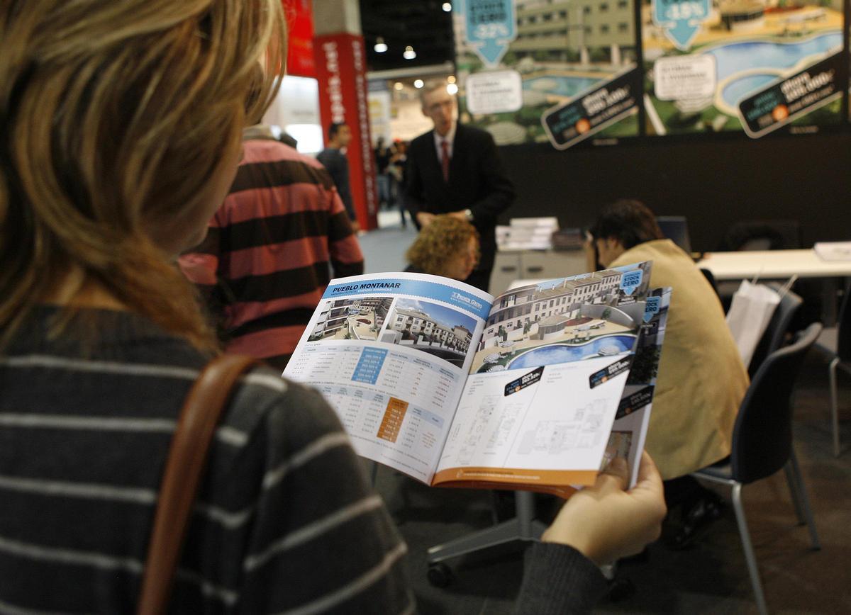 Una mujer busca piso en la feria Inmobiliaria Urbe.