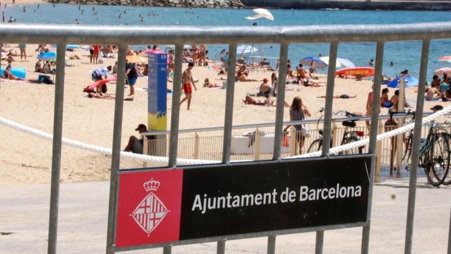 Imatge de la platja Nova Icària de Barcelona amb una tanca en primer pla aquest dissabte 18 de juliol