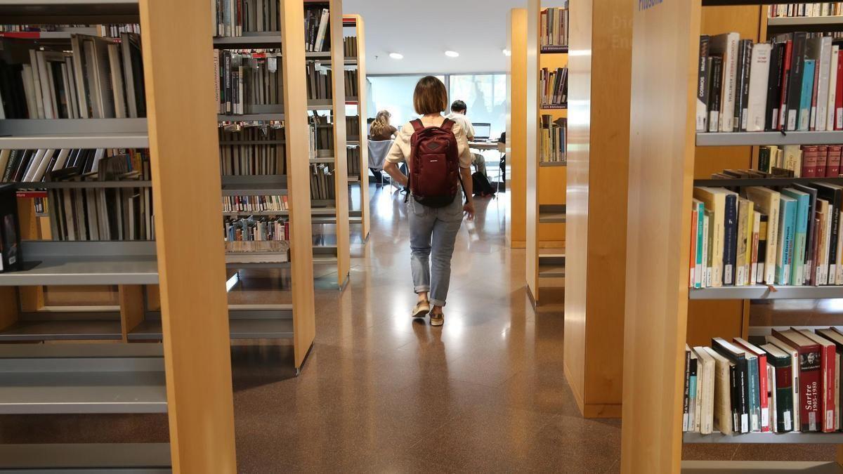 Una joven entra en una biblioteca de Barcelona.