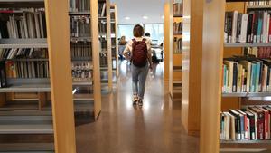Una joven, entra en una biblioteca de Barcelona para estudiar. / Ricard Cugat