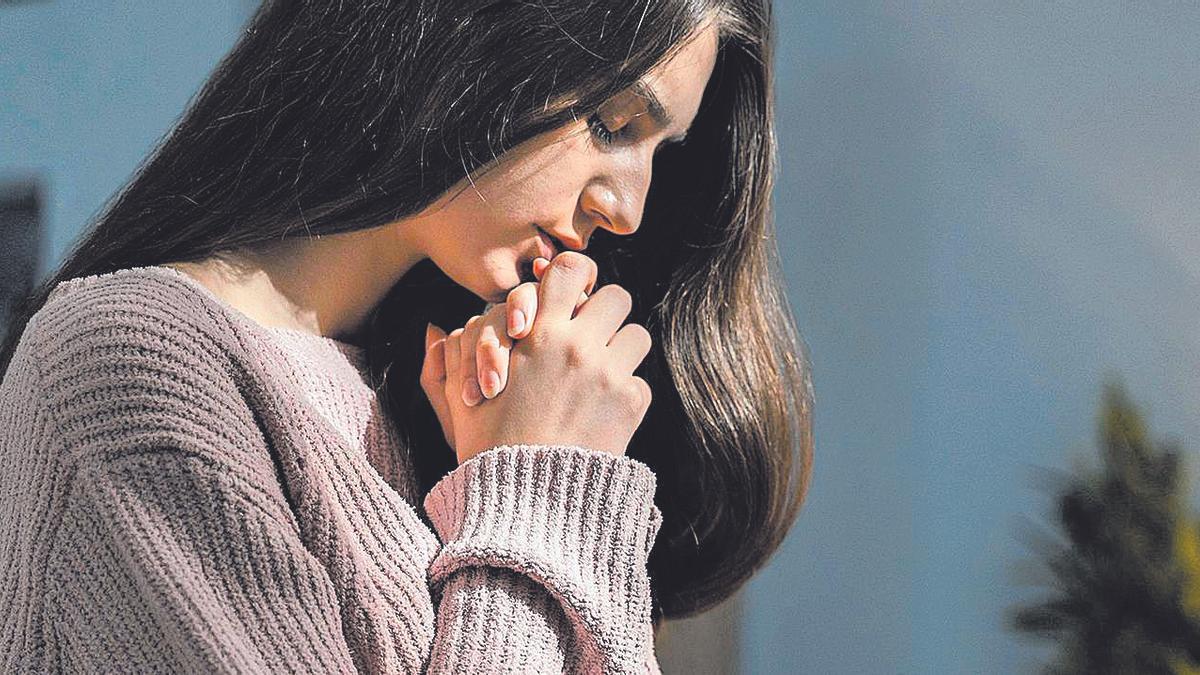 Una joven que reza en una imagen de archivo.