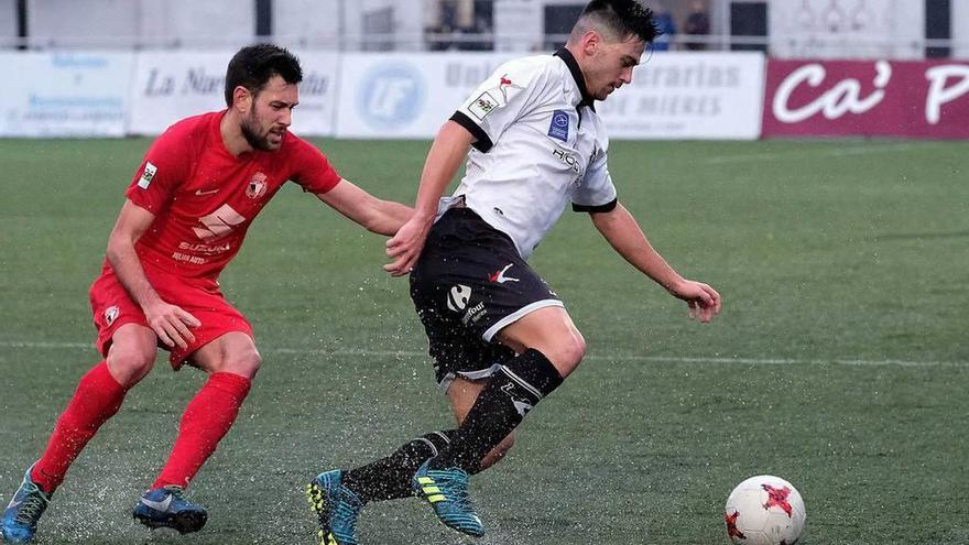 Catú conduce el balón perseguido por un jugador del Burgos.