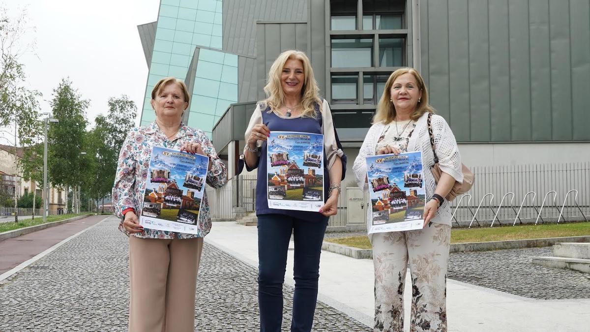 Amparo Cienfuegos, en el centro, junto a Pilar Presa y Mari Luz Villar, con carteles del encuentro coral