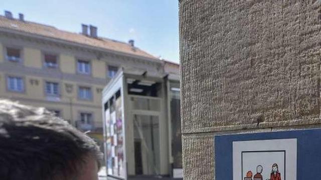 Una persona leyendo la placa del Servicio de Atención Ciudadana.
