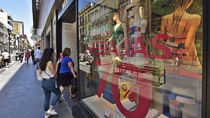 Los comercios empiezan a lucir los carteles de rebajas en la calle Triana.