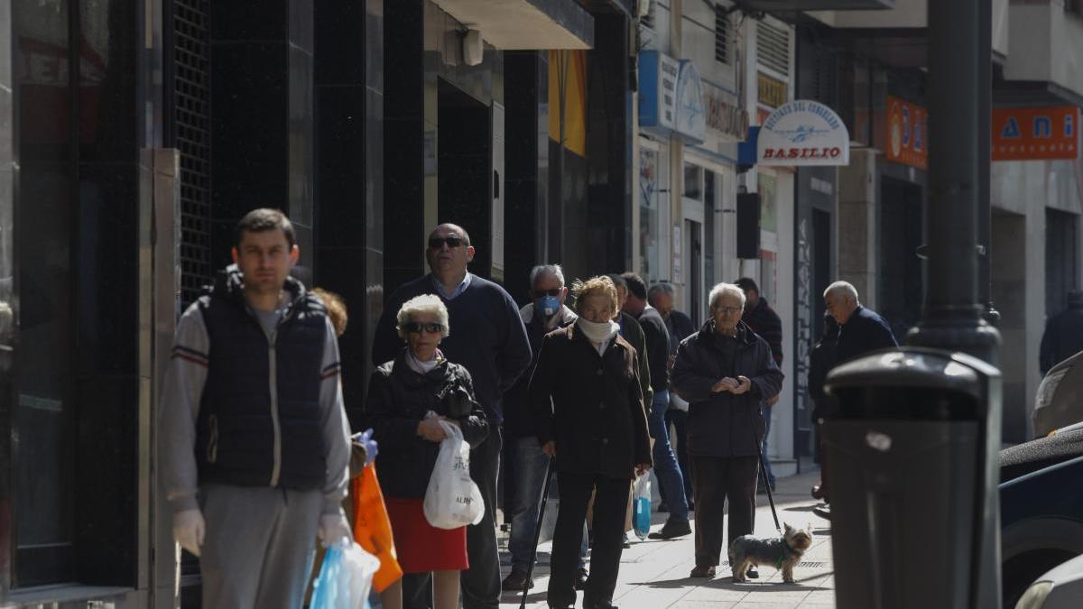 Varias personas haciendo cola en Avilés para comprar en un supermercado