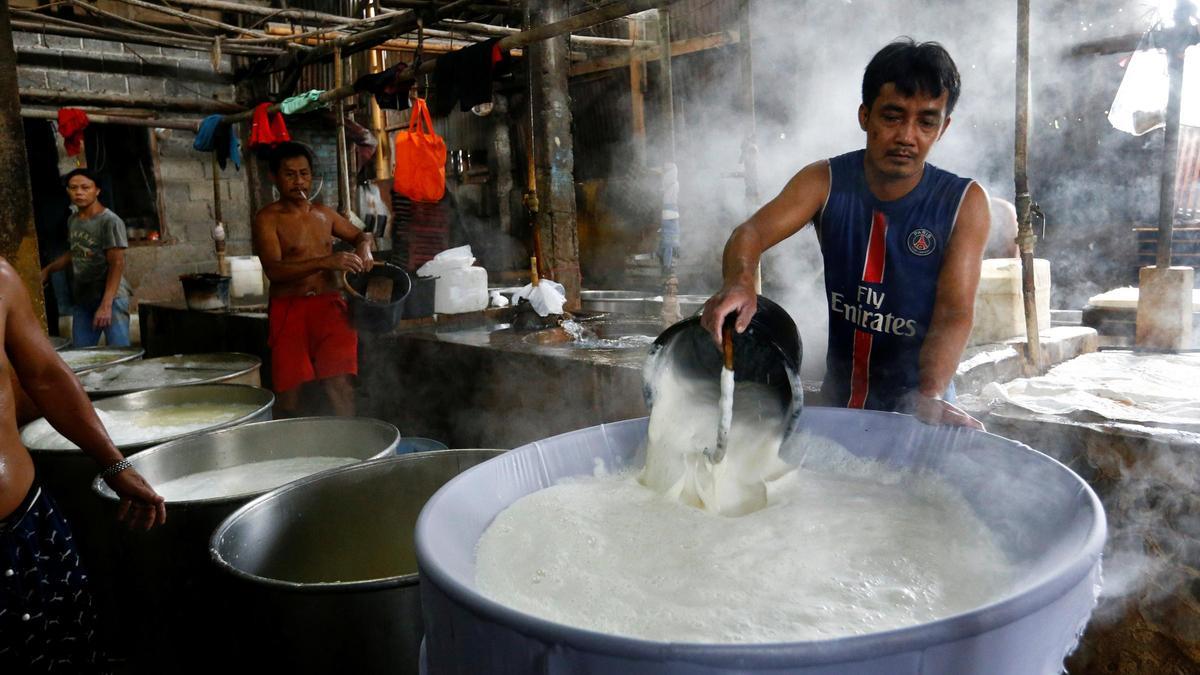 Workers cook soybean at a tofu factory in Jakarta