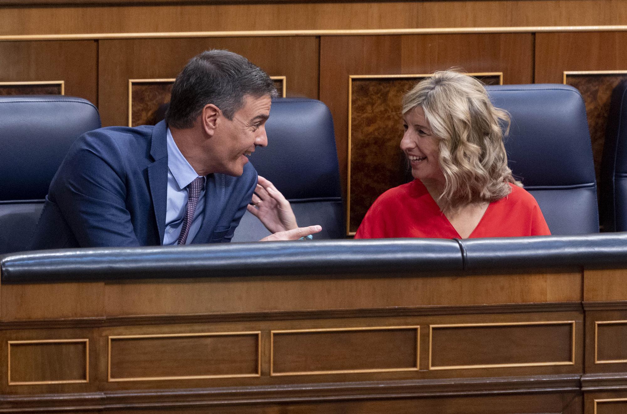 El presidente del Gobierno, Pedro Sánchez, conversa con la vicepresidenta segunda y ministra de Trabajo y Economía Social, Yolanda Díaz, durante un pleno extraordinario en el Congreso de los Diputados.