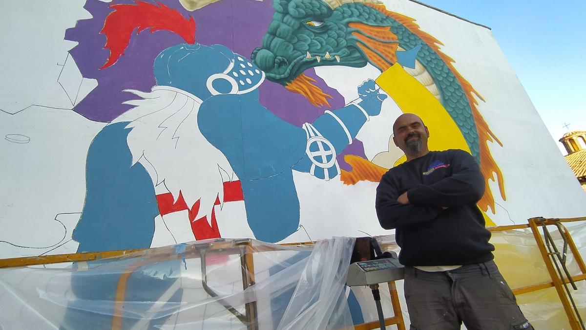 Víctor Manuel Lozano, ‘Lolo’, junto al mural contra la despoblación que está realizando en el municipio turolense de Odón.