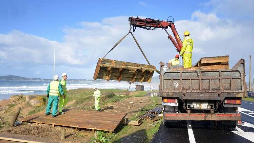 Los operarios, retirando los trozos de madera. // G.S.