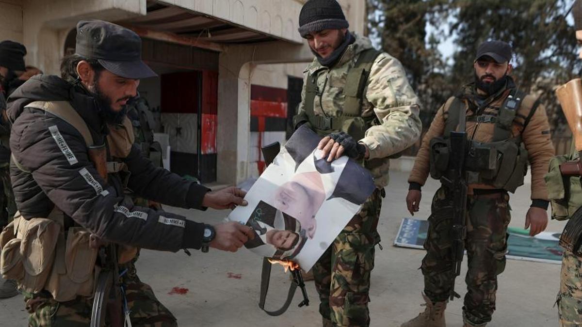 Combatientes prenden fuego a un retrato del presidente sirio Bashar al Assad el 29 de noviembre de 2024 en la región de Zarbah.