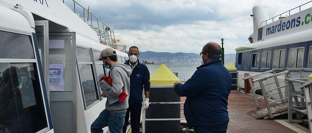 Usuarios del transporte de ría, embarcando, ayer, en los pantalanes de Cangas.