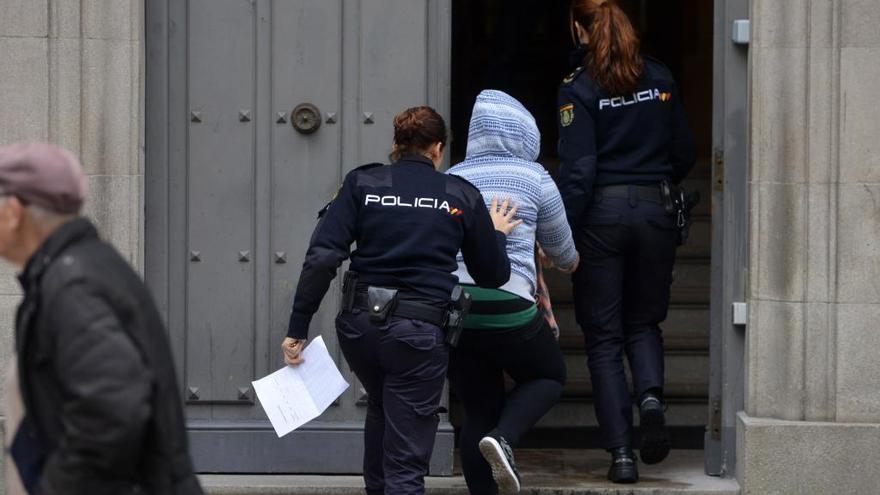 La Policía Nacional introduce a uno de los acusados en la Audiencia para el juicio.