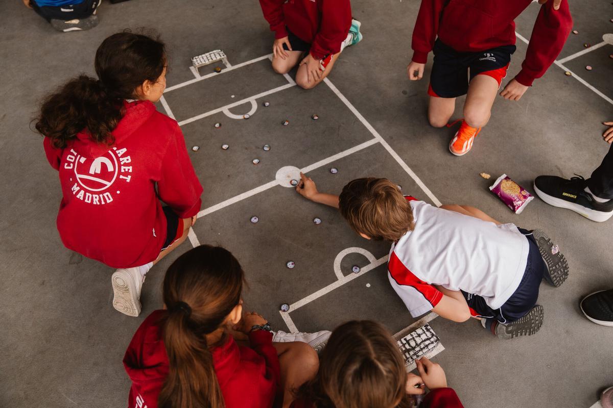 Niños juegan al fútbol chapa en el Colegio Claret de Madrid.