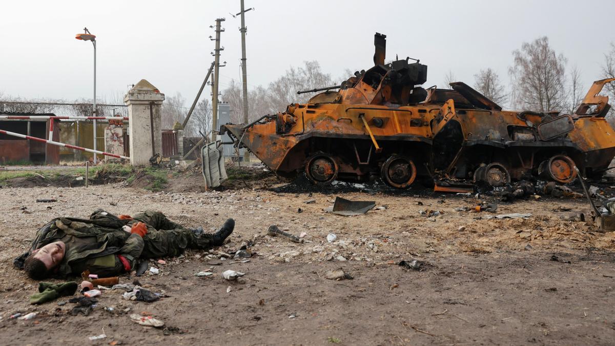 El cadáver  de un soldado ruso yace en el suelo frente a un vehículo blindado ruso BTR-82 destruido, en el pueblo de Nova Basan, Ucrania.