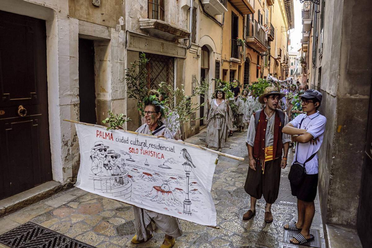 Vecinos de la Calatrava y Canamunt, muchos vestidos de verde y con ramas de árboles, se unen durante sus cercavilas para homenajear a los bellasombras talados en la plaza Llorenç Villalonga.