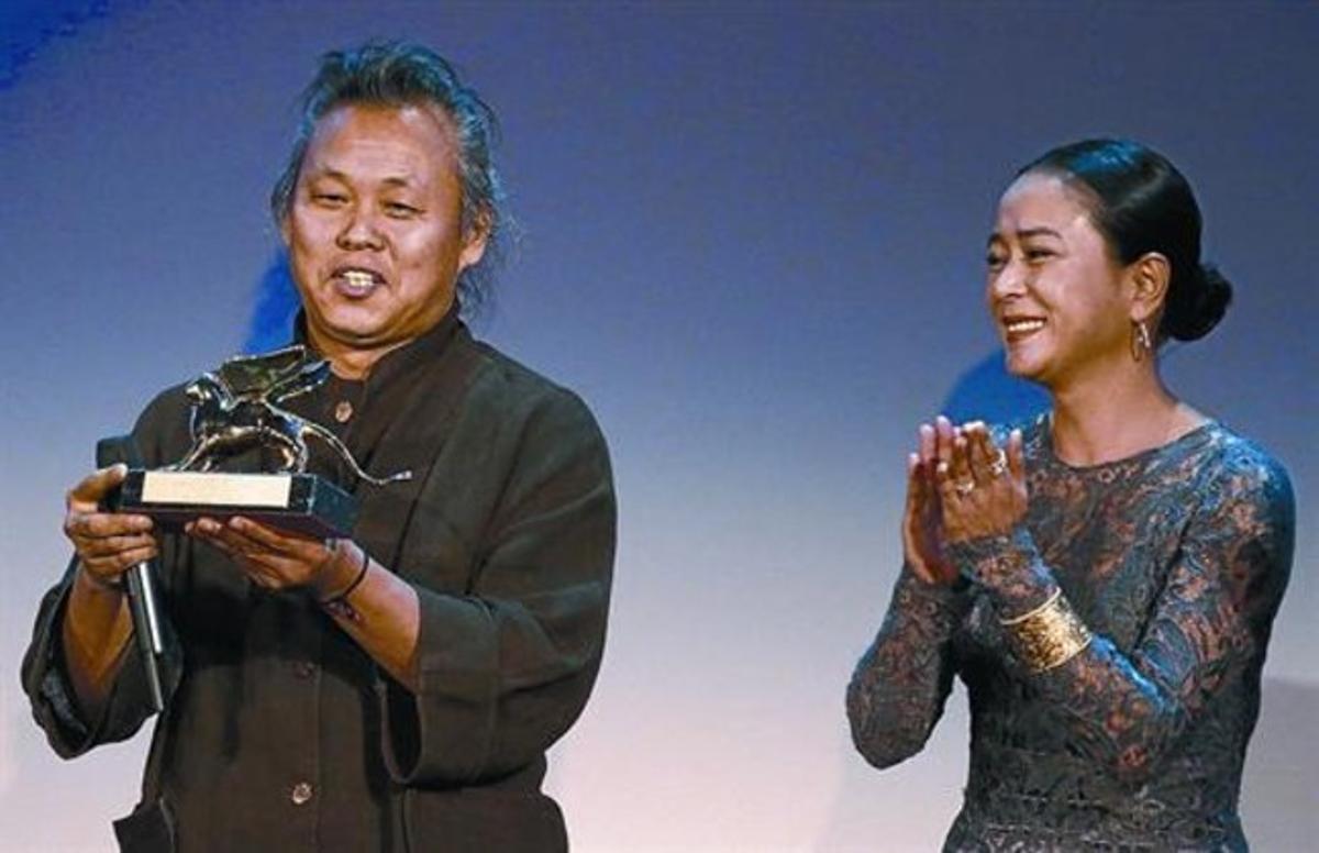 Kim Ki-duk, ayer en Venecia, en el momento de recibir el León de Oro acompañado de la actriz coreana Jo Min.