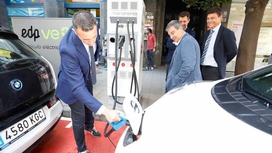 Esteban Aparicio, José María Pérez y Antonio González Lamuño contemplan la recarga rápida de un vehículo eléctrico en Álvarez Garaya.