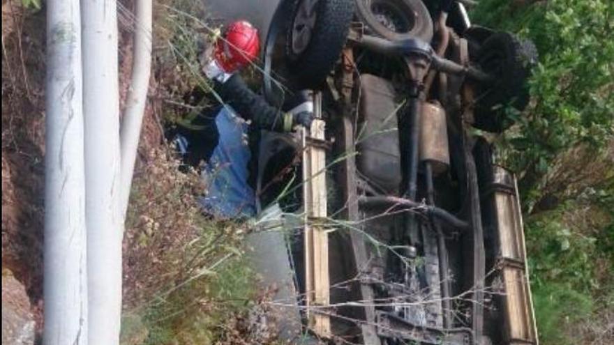 Uno de los bomberos, junto al vehículo siniestrado en Barlovento.