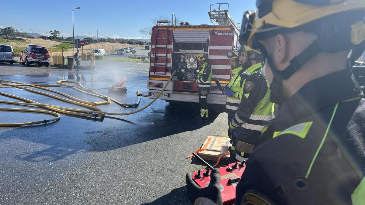 Un bombero de Pontevedra acciona con el control remoto el robot contra incendios.