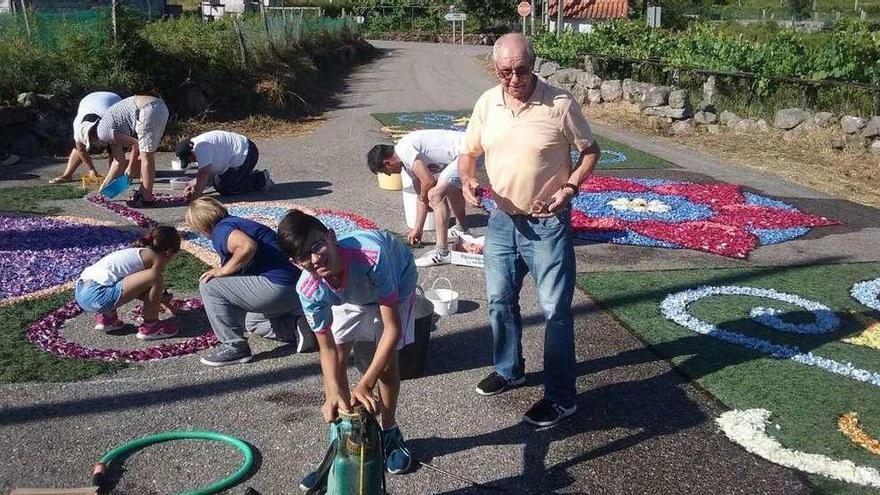 Vecinos de Chaín confeccionaron ayer las alfombras florales para la procesión del Encuentro.