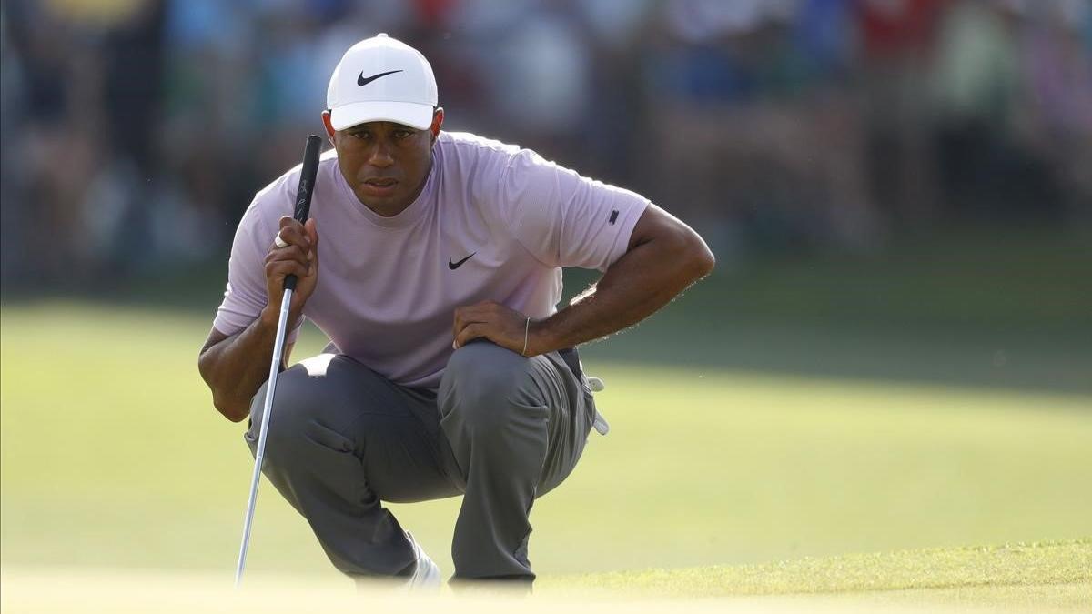 Tiger Woods observa una línea de putt en la tercera jornada