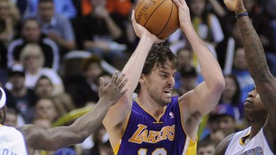 Pau Gasol trata de fajarse de Ty Lawson y Al Harrington, de los Nuggets, durante un partido de la liga regular.