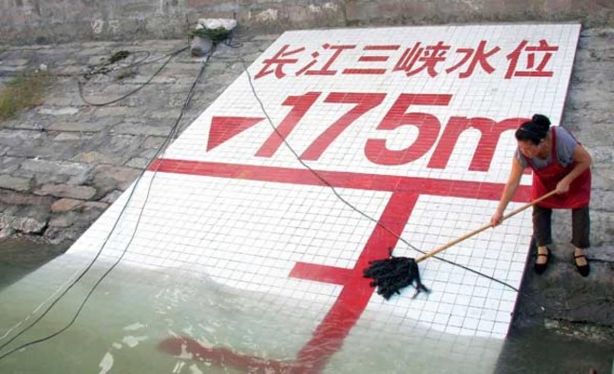 Una dona mostra el nivell de l’aigua a la ribera del riu Iang-Tsé a l’altura del districte de Wanzhou, al sud-oest de la Xina. L’aigua a la presa de les Tres Gorges va arribar ahir al seu màxim nivell.